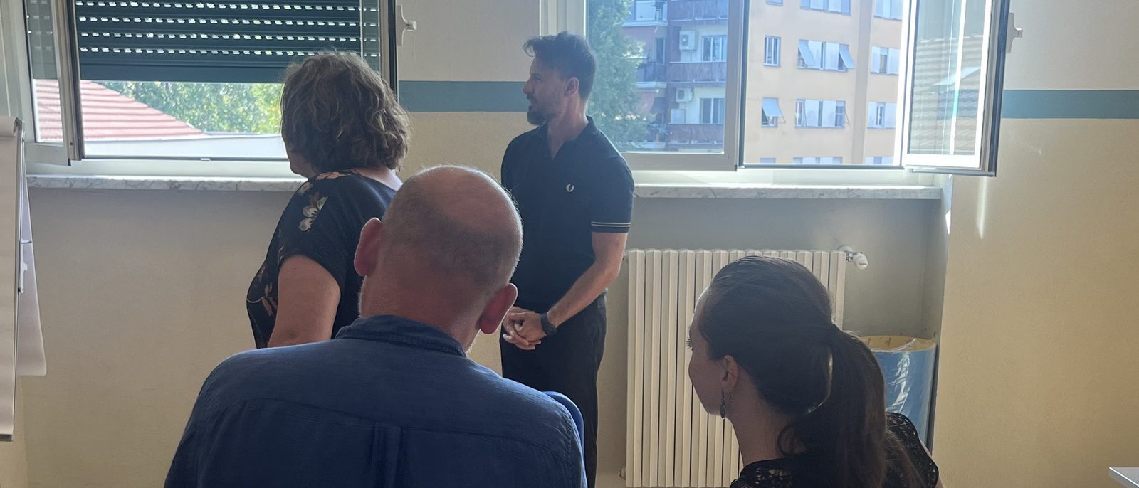 Teaching staff at Andersen International School, Milan, listening to a colleague in a bright room